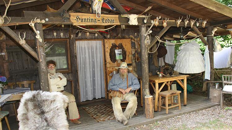 Auf dem Gelände der "Mountain Lions" in der Mörikestraße  gibt es viele Holzhütten, die der damaligen Zeit nachempfunden wurden. Dazu gehört die Hunting-Lodge, wovor es sich Friedrich Renk und Klaus Friedel gemütlich machen und dem Trubel des Festivals etwas entfliehen. Foto: Michael Stelzner