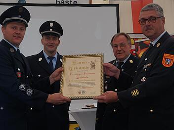 Die Ehrenurkunde zum 150-jährigen Bestehen der Feuerwehr Zeitlofs wurde überreicht: (von links) Kommandant Matthias Hauke, Vorsitzender Markus Ullrich, Kreisbrandrat Benno Metz und Kreisbrandinspektor Marco Brust. Foto: Marion Eckert