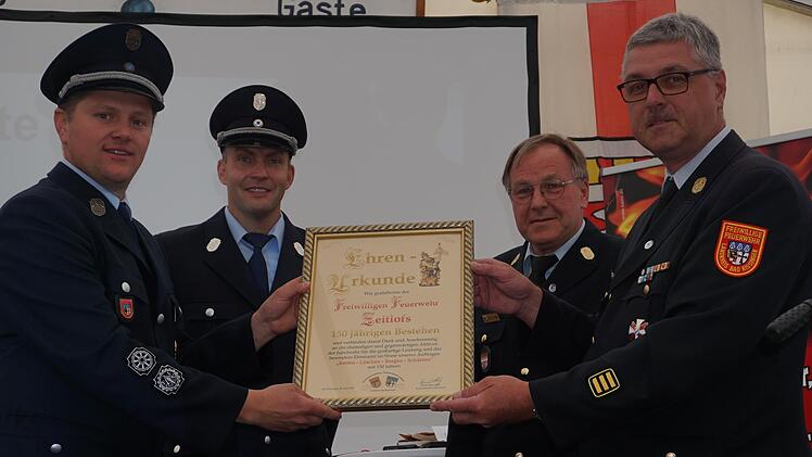 Die Ehrenurkunde zum 150-jährigen Bestehen der Feuerwehr Zeitlofs wurde überreicht: (von links) Kommandant Matthias Hauke, Vorsitzender Markus Ullrich, Kreisbrandrat Benno Metz und Kreisbrandinspektor Marco Brust. Foto: Marion Eckert