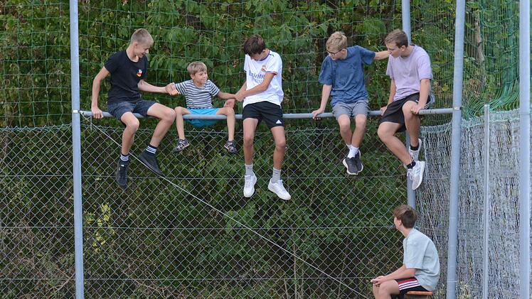 Beim Kreisliga-Match zwischen dem gastgebenden VfR Sulzthal und FV Rannungen/Pfändhausen/Holzhausen suchen sich die heimischen Jugendlichen einen besonderen Sitzplatz und helfen dem Jüngsten beim Aufstieg auf den Zaun. Die Partie endete  übrigens ...