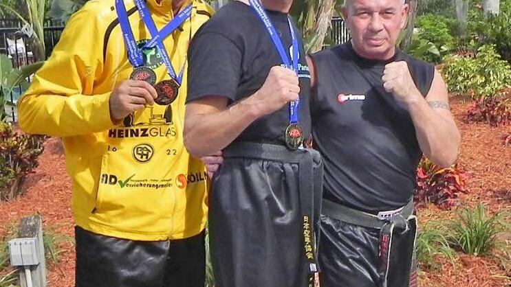 Die beiden erfolgreichen  Kickboxer Harun-Veysel Elkol  und  Norbert H&ouml;chner mit ihrem Trainer Harald R&ouml;gner (von links).  Foto:  p