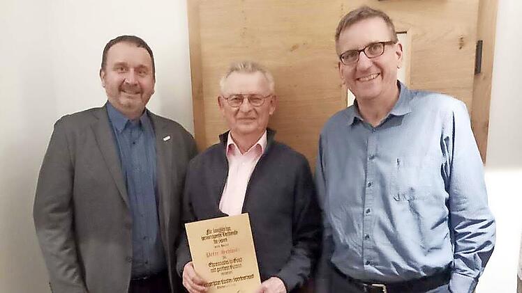 BLSV-Kreisvorsitzender Matthias Foerster (links) und Schatzmeister Dietmar Hofmann (rechts) überreichten Peter Schwitz die Ehrennadel in Gold mit großem Kranz des Bayerischen Landessportvereins.