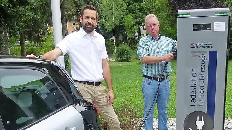 Jürgen Fiedler (l.) und Helmut Taut schließen einen nagelneuen Smart erstmals an die Zapfsäule in Muggendorf an. Foto: Paul Pöhlmann