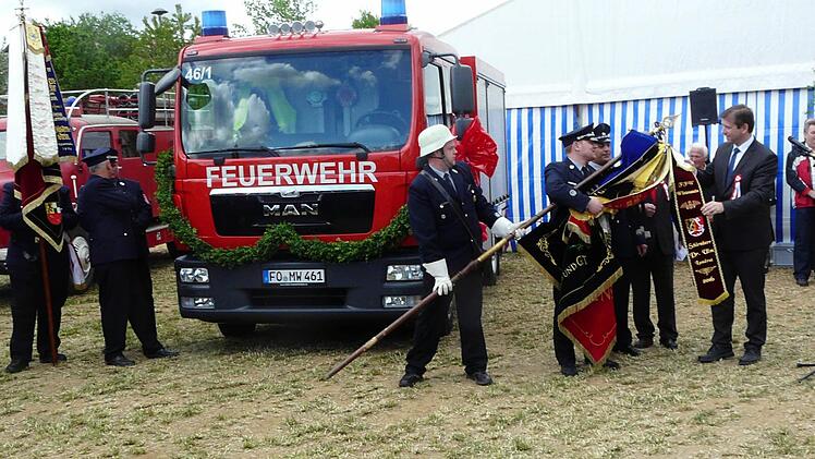 Die Übergabe des Fahnenbandes vor dem neuen Fahrzeug der Wehr Foto: Paul Pöhlmann