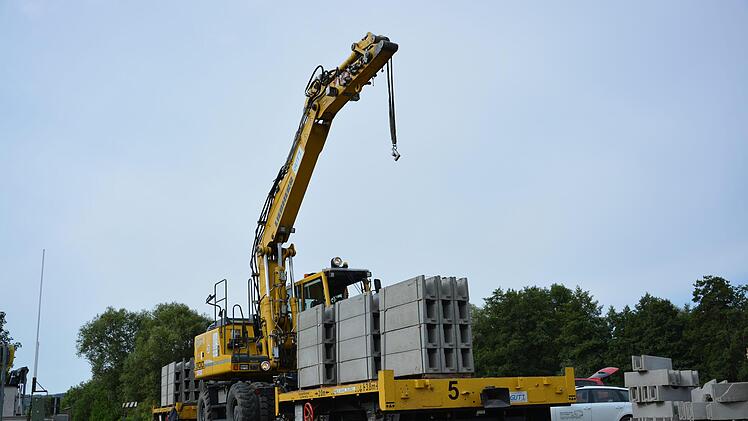 Ein Kran auf Schienen verlegt die vorgefertigten Betonteile entlang der Bahnstrecke zwischen Burglauer und Mellrichstadt. Am Samstag sollen die Arbeiten abgeschlossen sein.  Foto: Björn Hein