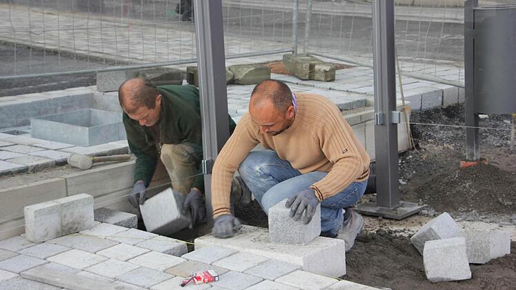 Millimeterarbeit ist beim Pflastern durch Agostinho (links) und Bruno Perreira gefragt.  Foto: Friedwald Schedel