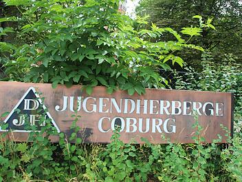 Das verwitterte, schon etwas zugewachsene Schild der einstigen Jugendherberge Coburg symbolisiert, wie es derzeit um die Zukunft einer solchen Einrichtung aussieht - traurig. Foto: Helke Renner