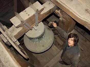 Monteur Timm Nagel begutachten die historische Turmuhr in der Jakobuskirche. Der Monteur prüft den Hammer außerhalb der Glocke, der für das Schlagen, also die Töne zur Angabe der Uhrzeit zuständig sind.  Fotos: Ralf Ruppert