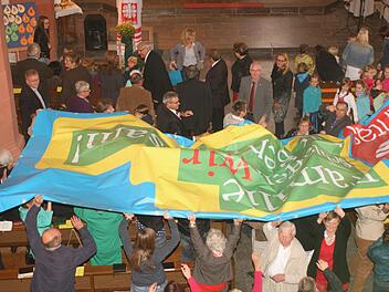Viele Hände trugen das Banner mit der Aufschrift "Familie schaffen wir nur gemeinsam" durch die Stadtpfarrkirche Haßfurt. Fotos: Günther Geiling