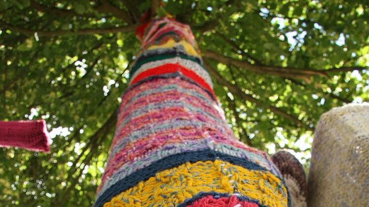 Aus bunten Strickteilen ist die Hülle entstanden, die einen Baum verziert.