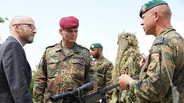 Peter Tauber (links), parlamentarischer Staatssekret&auml;r im Verteidigungsministerium, l&auml;sst sich ein Scharfsch&uuml;tzengewehr erkl&auml;ren. Brigadegeneral Andreas Hannemann (Mitte) begleitet ihn beim Rundgang &uuml;ber die Ausstellung der infanteristischen Truppenteile. Foto: Arkadius Guzy