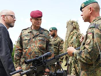 Peter Tauber (links), parlamentarischer Staatssekretär im Verteidigungsministerium, lässt sich ein Scharfschützengewehr erklären. Brigadegeneral Andreas Hannemann (Mitte) begleitet ihn beim Rundgang über die Ausstellung der infanteristischen Truppenteile. Foto: Arkadius Guzy