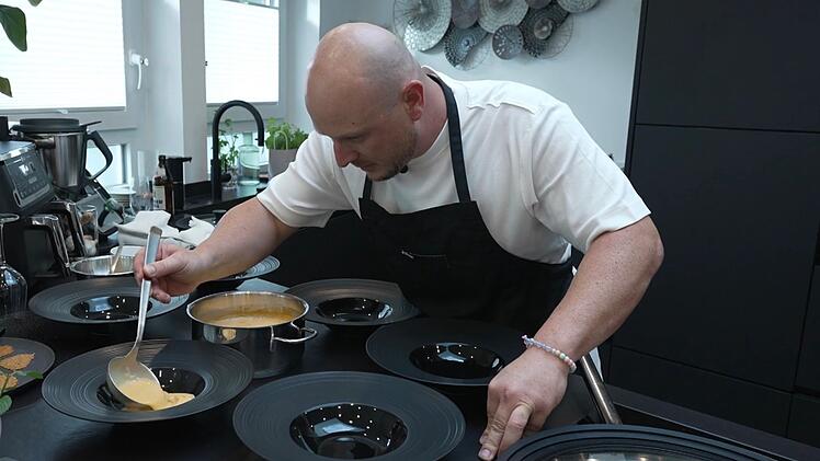 Julian (36) ist beim Anrichten der Hummersuppe höggscht konzentriert.