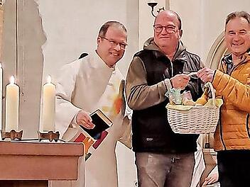 Unser Bild zeigt Diakon Manfred M&uuml;ller, Organist Harald Drescher und Kirchenpfleger Bernd H&uuml;fner bei der &Uuml;bergabe des Geschenkkorbs.
