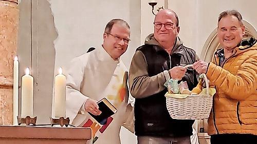 Unser Bild zeigt Diakon Manfred M&uuml;ller, Organist Harald Drescher und Kirchenpfleger Bernd H&uuml;fner bei der &Uuml;bergabe des Geschenkkorbs.