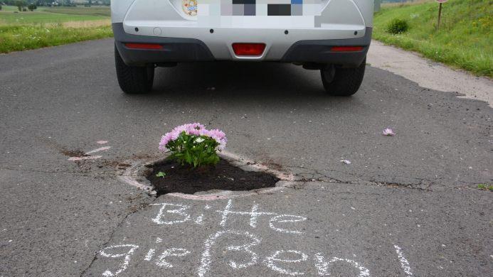 "Bitte gie&szlig;en" - im Kreis Rh&ouml;n-Grabfeld in Unterfranken hat ein Unbekannter ein Schlagloch versch&ouml;nert. Foto: Hanns Friedrich
