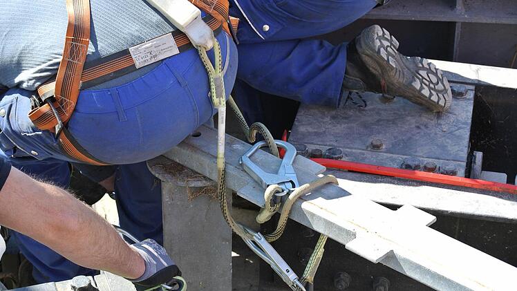 Keiner darf ungesichert am Rand der Schleusenkammer arbeiten. Die Arbeiter, die beispielsweise das Halslager anhängen, tragen alle eine Sicherung per Seil.