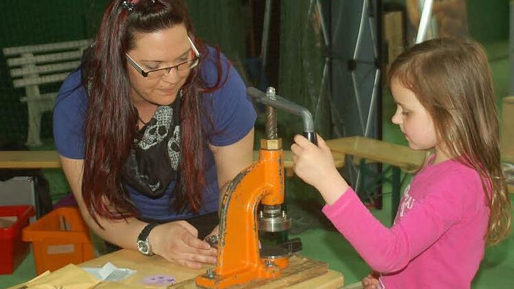 38 Nele Fügner gestaltet Buttons am Stand der Ejott unter der Anleitung von Petra Fenski . Foto: Gabi Arnold
