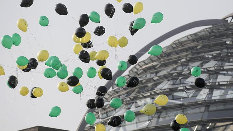 Luftballons in den Jamaika-Farben fliegen in Berlin neben dem Reichstag gegen&uuml;ber der Parlamentarischen Gesellschaft. Symbolfoto: Michael Kappeler/dpa