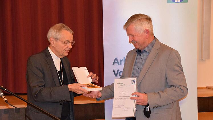 Erzbischof Ludwig Schick &uuml;berreicht die Urkunde zusammen mit  der Bronzemedaille  an Volker Griebel.