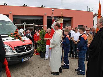 Diakon Bernhard Trunk (links) und Pfarrer Hans-Christian Neiber (rechts) haben sowohl den Erweiterungsbau der Feuerwehr als auch das neue Einsatzfahrzeug der Wasserwacht (im Bild) unter Gottes Segen gestellt.