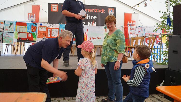 Helmut Kühn und Robert Müller von der Münnerstädter Feuerwehr verliehen die Preise des Malwettbewerbs. Foto: Kerstin Denner-Kleren