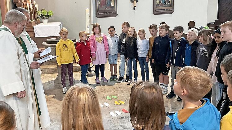 Die beiden Geistlichen verabschieden die Schülerinnen und Schüler in die Ferien.