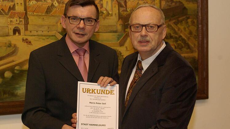 Bürgermeister Armin Warmuth (links) verabschiedete den langjährigen Amtsleiter Peter Sell (rechts) aus den Diensten der Stadt mit einer Dankesurkunde.  Foto: Winfried Ehling
