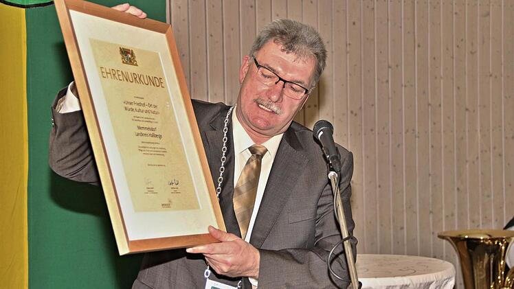 Stolz zeigte Bürgermeister Helmut Dietz die Urkunde, welche die Gemeinde für die Gestaltung ihres Friedhofes in Memmelsdorf erhalten hat. Foto: Helmut Will
