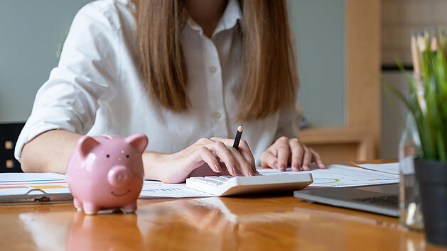 Frau rechnet Kosten aus.