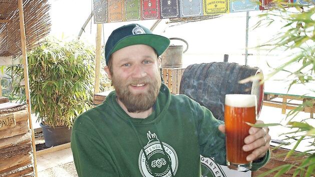 Kris Emmerling präsentiert seinen Hopfen und sein selbst gebrautes Rauchhopfenbier.  Fotos: Stadt Bamberg