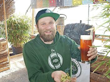 Kris Emmerling präsentiert seinen Hopfen und sein selbst gebrautes Rauchhopfenbier.  Fotos: Stadt Bamberg