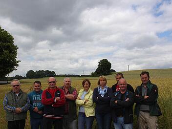 Sie wollen nicht, dass die Felder hinter ihnen bebaut werden: (von links) Klaus Tauer, Sven Partenfelder, Kurt Hacker, Herbert Ponater, Anja Schwarz, Anja Griese, Egon Dörfler, Wolfgang List und Horst Hacker. Foto: Jürgen Gärtner