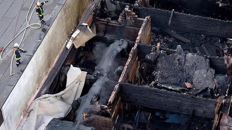Feuerwehrleute löschen am Sonntag (13.05.2012) die letzten Brandherde in den Ruinen des Kristallbades in Fichtelberg-Neubau Foto: David Ebener dpa