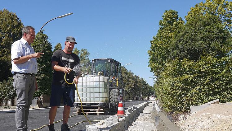 Das wird auch noch fertig: Mit dem Erstellen und Asphaltieren der Gehwege in der Coburger Straße hat sich die Baufirma  der Rossacher Dorferneuerung in die zweiwöchige Sommerpause verabschiedet. Udo Siegel (links) und Marcel Becherer haben  zuvor noch mal die letzten Details abgesprochen.Berthold Köhler