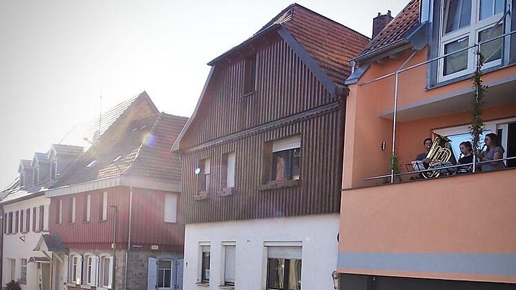Familie Gerlach spielt auf ihrem Balkon. In der Von-Hess-Straße haben sich schon einige Zuhörer eingefunden. Bianca Volkert