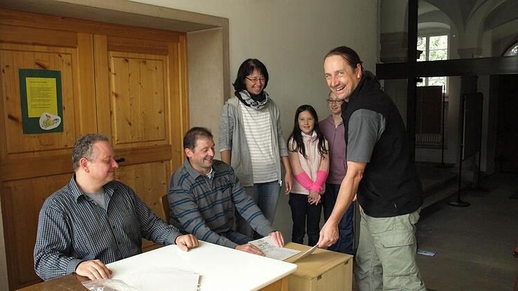 Michael Zieg (rechts) kam mit der ganzen Familie, um im Schloss Gleisenau seinen Wahlschein abzugeben. Mit im Bild sind Wahlhelfer Gerhard Koch sowie Claudia, Maja und Emma Zieg (von links). Foto: Katja Kölbl