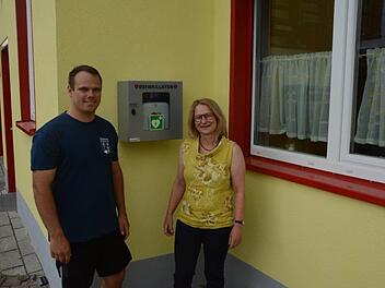 Feuerwehrkommandant Florian Ziegler Ortsbeauftragte Elisabeth Assmann freuen sich über den Defibrillator in Diebach. Dieter Ebert