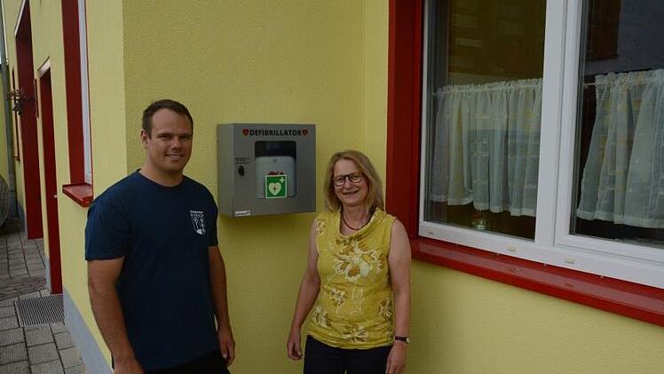 Feuerwehrkommandant Florian Ziegler Ortsbeauftragte Elisabeth Assmann freuen sich über den Defibrillator in Diebach. Dieter Ebert