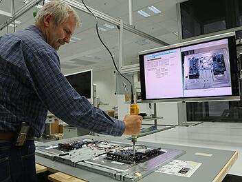 Schichtleiter Jürgen Hoffmann zeigt, wie es geht: In der Kronacher Produktion entsteht jeweils aus vielen kleinen Einzelkomponenten ein Loewe-Fernseher. Auch die bei der Ifa präsentierten neuen Gerätelinien sollen in Kronach gefertigt werden. Foto: Barbara Herbst