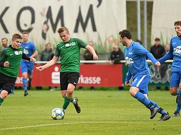 Der Neukenrother Florian Maurer (gr&uuml;nes Trikot, rechts) zieht den Abwehrspieler der DJK Lichtenfels, Dominik Woitschitzke (blaues Trikot, links), auf sich, spielt den Ball dann in die Gasse, in die sein Mitspieler Felix Maurer (links) l&auml;uft und zum 0:2 abschlie&szlig;t.  Foto: Gunther Czepera