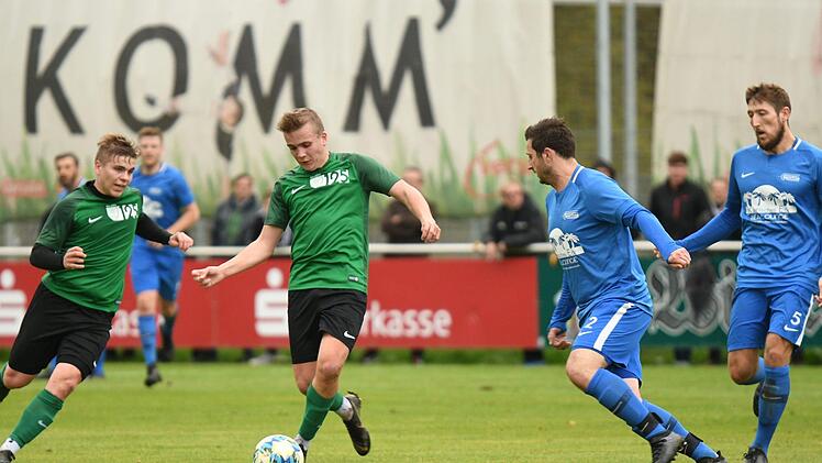 Der Neukenrother Florian Maurer (gr&uuml;nes Trikot, rechts) zieht den Abwehrspieler der DJK Lichtenfels, Dominik Woitschitzke (blaues Trikot, links), auf sich, spielt den Ball dann in die Gasse, in die sein Mitspieler Felix Maurer (links) l&auml;uft und zum 0:2 abschlie&szlig;t.  Foto: Gunther Czepera