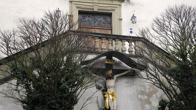 Ein Kruzifix hängt vor dem Portal Stadtkirche von Arnstein (Landkreis Main-Spessart) bei Würzburg (Bayern), aufgenommen am 30.01.2017. In der Stadtkirche soll am Abend eine nicht-öffentliche Trauerstunde für die Angehörigen der Opfer stattfinden. Ein Vater hatte am Vortag sechs Leichen in seinem Gartenhäuschen bei Arnstein gefunden, darunter seine eigenen Kinder. Foto: Bastian Benrath/dpa