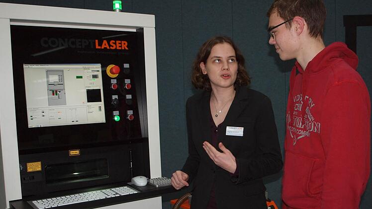 Der 17-jährige Gymnasiast Lukas Eller, der an einem technischen Beruf interessiert ist, lässt sich von Dagmar Wohlfahrth von der Firma Laser Concept die Funktionsweise der Metall-Laserschmelztechnologie erklären.