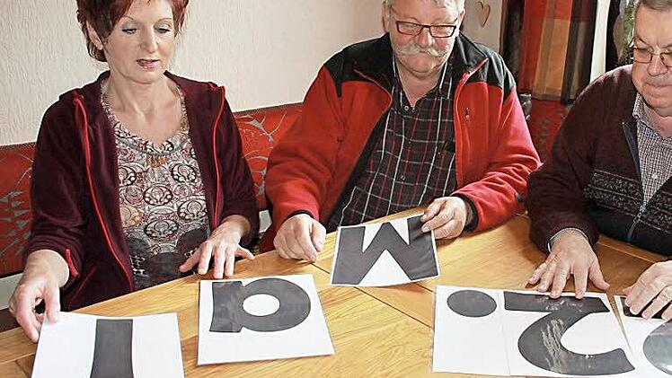 Uschi und Franz Zillig sortieren zusammen mit Pfarrer Rudolf Scharf die Buchstaben des wichtigen Datums. Am 22. Mai soll in Eggenbach kräftig gefeiert werden. Das Ziel: möglichst viel Geld für Kühe in Stufu einnehmen.  Foto: Andreas Schmitt