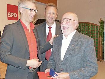 Oberbürgermeister Uwe Kirschstein (links) und Michael Hartmann freuen sich mit dem Geehrten Rainer Herrnleben.  Foto: Pauline Lindner
