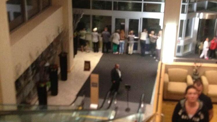 Bevor das Betreten der Hotellobby verboten wird, beobachten die Gäste durch die Glasscheiben, wie der Sturm wütet.