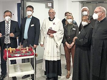 Chefarzt Martin Grauer (l.) und Landrat Alexander Tritthardt (Zweiter v. l.) bringen im Foyer des Kreiskrankenhauses St. Anna die ersten Aufkleber mit dem Neujahrssegen an. Diakon Georg Paszek (Mitte) leitete als Krankenhausseelsorger die Segensfe...