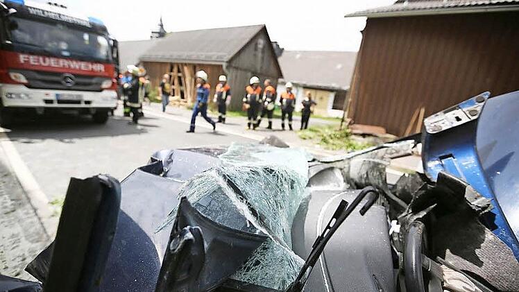 Gegen 12.40 Uhr kollidierte ein junger Mann in seinem Wagen mit zwei Gebäuden in Effelter. Erst riss das Fahrzeug Bretter aus der Scheunenwand links oben. Dann endete die Fahrt mit einem Krachen am Sockel des dunklen Hauses rechts. Fotos: Hendrik Steffens