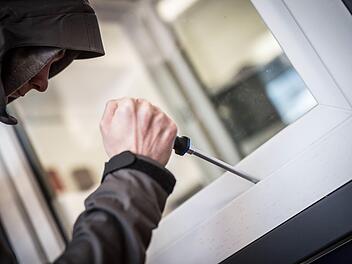 Ein Mann demonstriert in einer polizeilichen Beratungsstelle, wie einfach es für einen Einbrecher wäre, mit Hilfe eines stabilen Schraubenziehers ein geschlossenes Fenster von außen zu öffnen. Foto: Frank Rumpenhorst, dpa